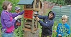 W&auml;hrend Saskia Zigan (v.l.) und Christoph Bebber das Insektenhotel im &Ouml;ko-Garten der Ganztagsschule Ciervisti mit Heu auff&uuml;llen, sorgen Dustin Ludwig und Tim Feierabend daf&uuml;r, dass eine Informationsblatt am Hotel befestigt wird.
