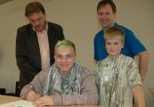 Marvin (links) und Nico sind eine Patenschaft eingegangen. Mirko Enke vom Rotary Club (hinten links) und Ganztagsschulkoordinator Ralph Schammer unterzeichnen den Vertrag auch.