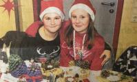 Evelina und Laura verkaufen im Speiseraum der Schule selbstgebastelte Weihnachtsdekoration. Sie hoffen auf viel Umsatz.