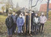 Einige Schüler der Klasse (Leon, Christian, Jaylen, Jamy, Nevio, Mathis, Emma, Angelina, Vanessa) mit ihrem nun eingepflanzten Baum.